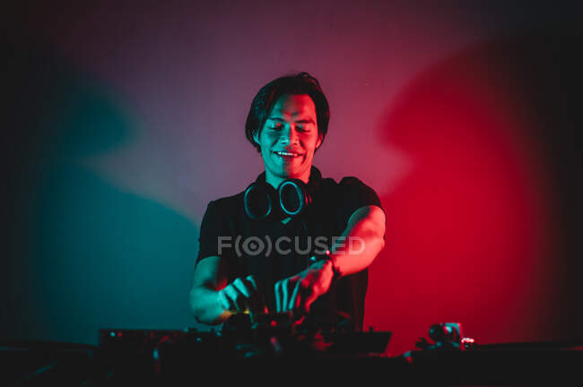 Porträt des DJs, der über Kopfhörer die Lautstärke mixt und reguliert — Stockfoto