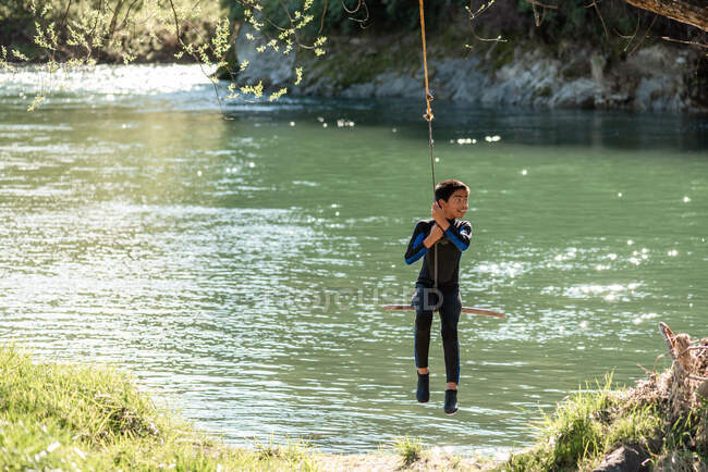 Jovem adolescente na corda balança sobre o rio na Nova Zelândia — Fotografia de Stock