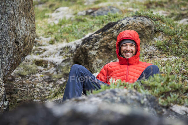 Портрет усміхненого альпініста, що відпочиває на альпійському лузі — стокове фото