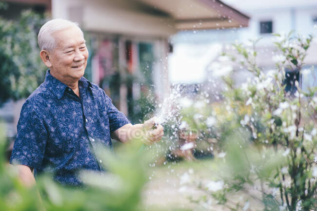Feliz asiático homem sênior em seu jardim. Idade da reforma feliz. — Fotografia de Stock