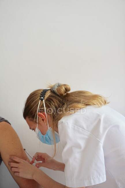 Vaccine put young nurse with hand — Stock Photo