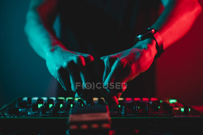 Close-up de mãos Dj misturando e ajustando o volume em um sintetizador — Fotografia de Stock