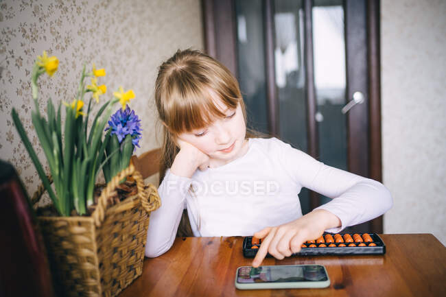 Девочка учится рассчитывать на счеты — стоковое фото