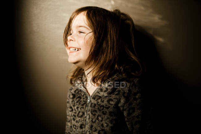 Молодая девушка в пижаме леопарда смеется днем — стоковое фото