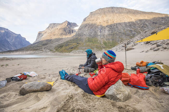 Los montañistas se relajan en un día soleado en el campamento base, la isla de Baffin - foto de stock
