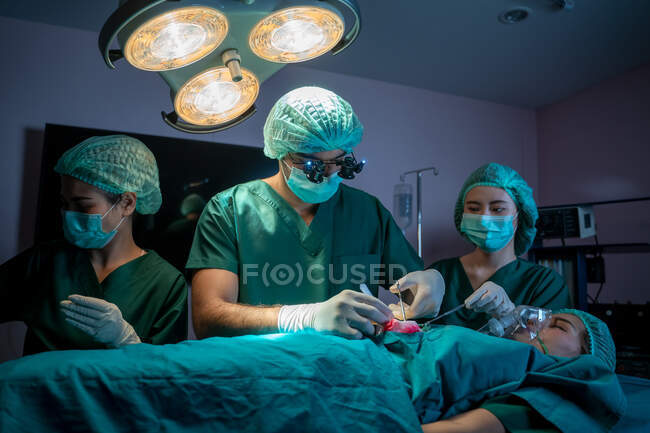 Chirurgen mit Assistenten operieren im Operationssaal des Krankenhauses, medizinisches Team führt Operationen durch. — Stockfoto