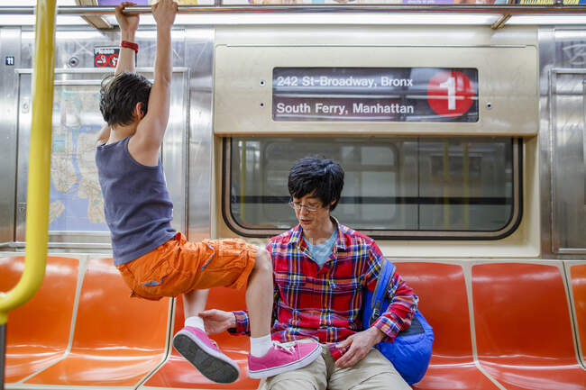 Piccolo ragazzo appeso al corrimano in metropolitana di New York e il padre lo tira giù — Foto stock