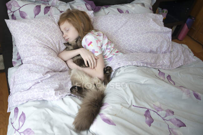Krankes kleines Mädchen schläft im Bett mit Katze — Stockfoto
