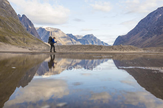 Reflexión del senderismo con mochila en Akshayuk Pass, Baffin Island, Canadá. - foto de stock