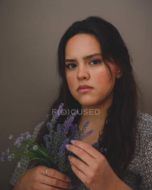 Portrait of a young beatiful hispanic woman on a grey background — Stock Photo