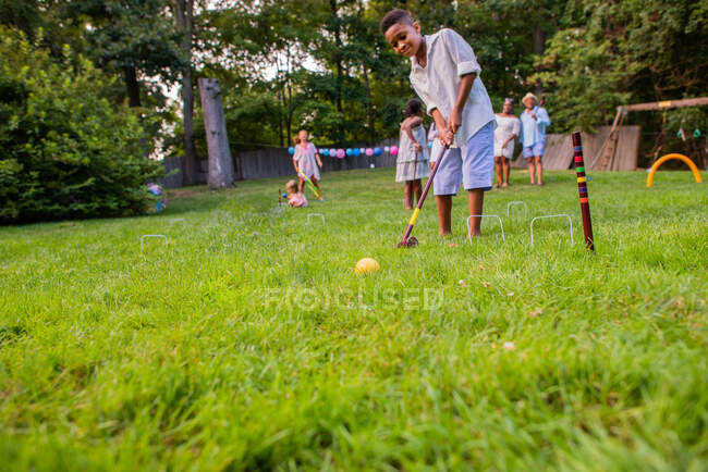 Niño jugando cricket o croquet - foto de stock