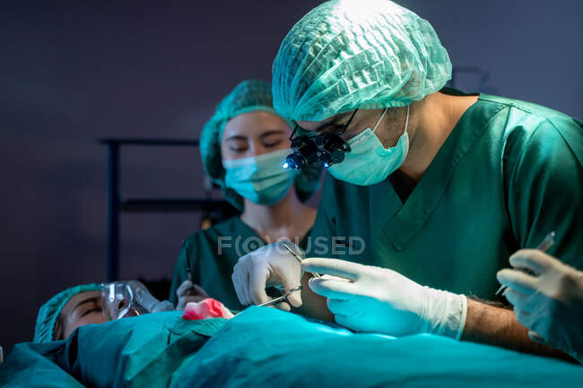 Хірурги з асистентами оперують в операційній палаті лікарні, де працює медична бригада.. — Stock Photo