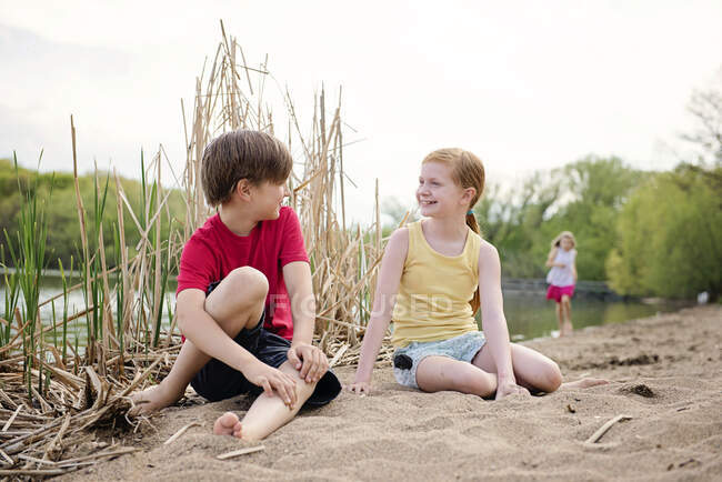 Enfants jouant dans le sable au bord d'un lac — Photo de stock
