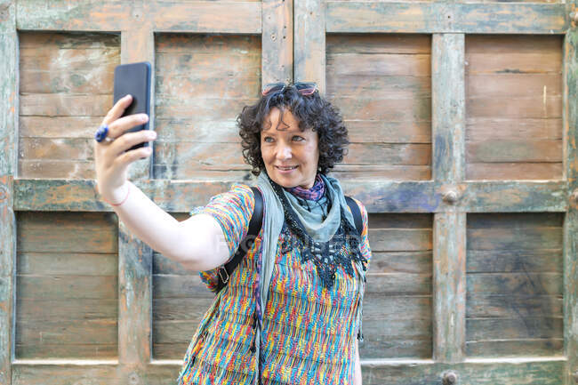 Mulher moderna de meia-idade tirando uma foto de seu smartphone — Fotografia de Stock