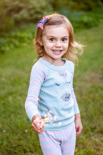 Retrato de una linda niña en un vestido rosa con una corona de flores - foto de stock