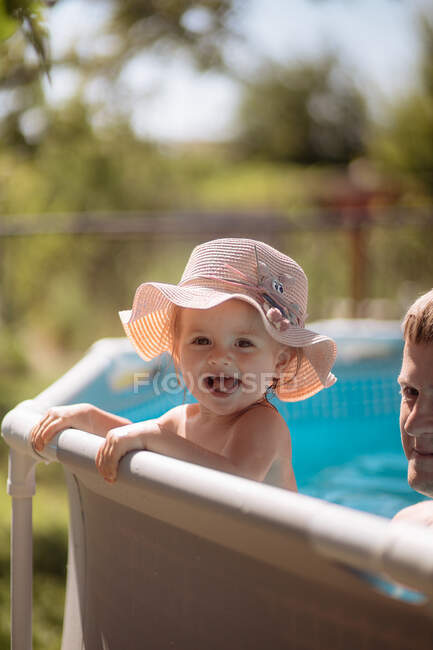 Маленька дівчинка в капелюсі плаває в басейні — стокове фото