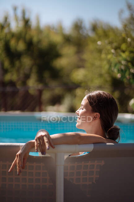 Menina no backlight na piscina do jardim — Fotografia de Stock