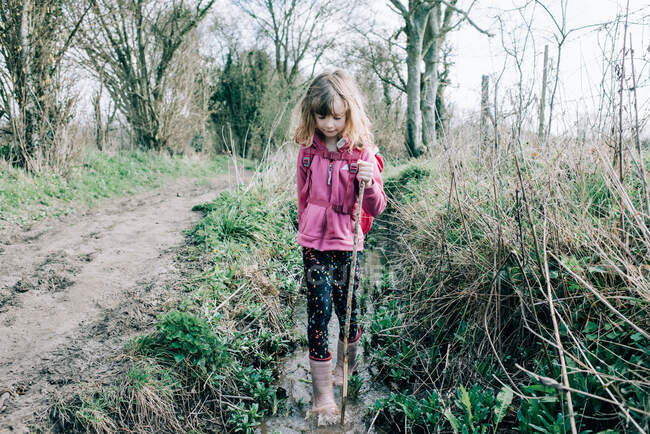 Young girl walking through a stream exploring whilst hiking in the UK — Stock Photo