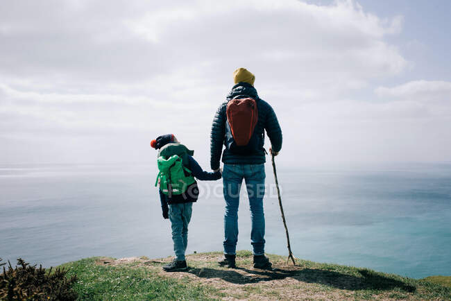 Father and son stood at the top of the Jurassic coast in Dorset, UK — Stock Photo