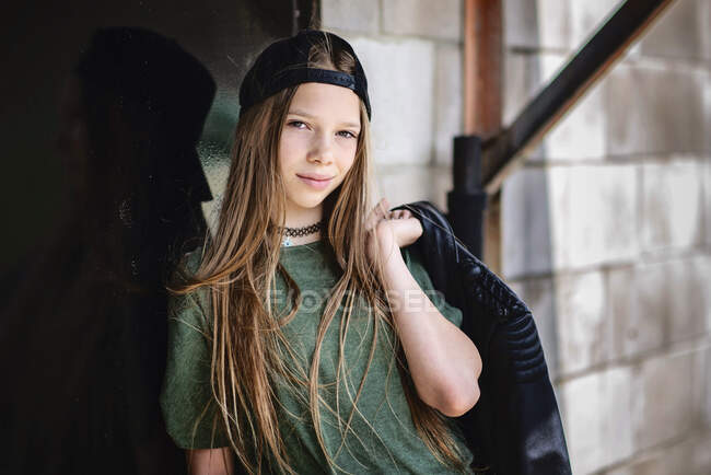 Tween girl with blond hair and black jacket hanging out in the city. — Stock Photo