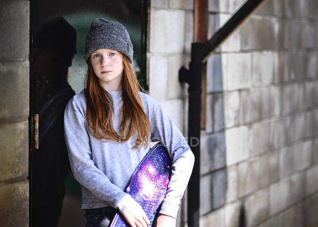 Між дівчиною з рудим волоссям і капелюхом позує зі скейтбордом . — стокове фото