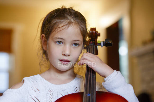 Nahaufnahme von fokussierten süßen Mädchen üben Cello zu Hause, — Stockfoto