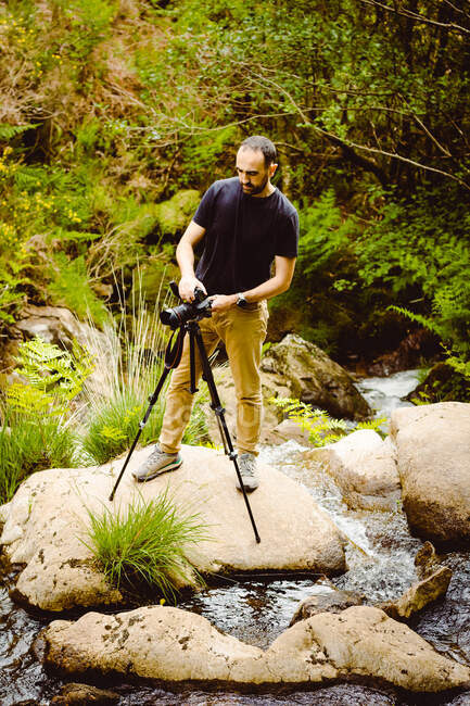 Photographer in black t-shirt in nature — Stock Photo