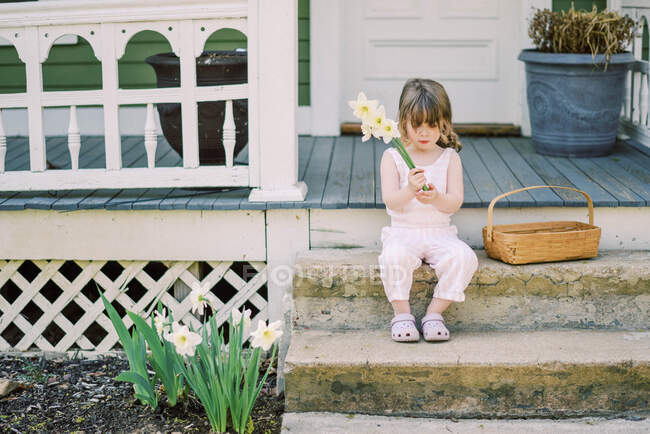 Маленька дівчинка з букетом квітів у парку — стокове фото