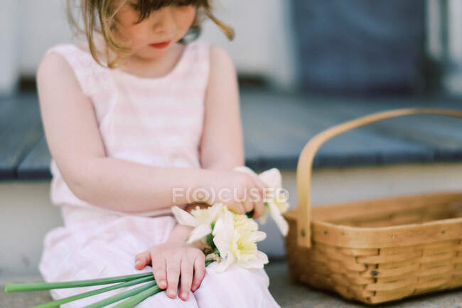 Little girl with a basket of flowers — Stock Photo