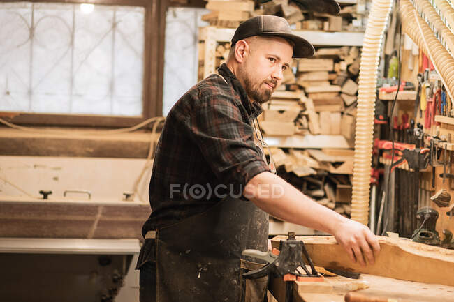 Joven carpintero profesional que trabaja en el taller - foto de stock