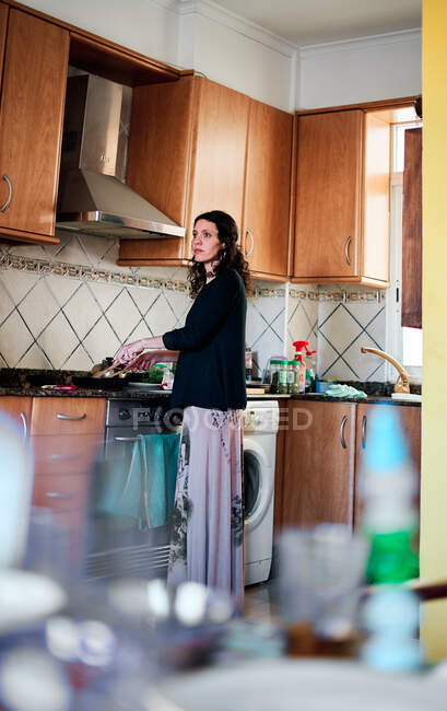 Latin woman cooking in the kitchen at home — Stock Photo