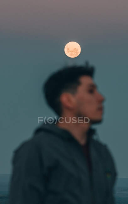 Pleine lune avec jeune homme dans le flou — Photo de stock