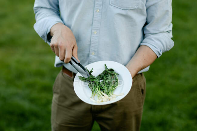 Nahaufnahme eines Mannes mit frischen grünen Blättern, Nahaufnahme — Stockfoto