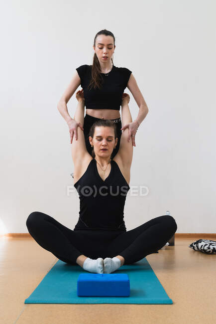 Donna con allenatore che fa esercizio di stretching — Foto stock