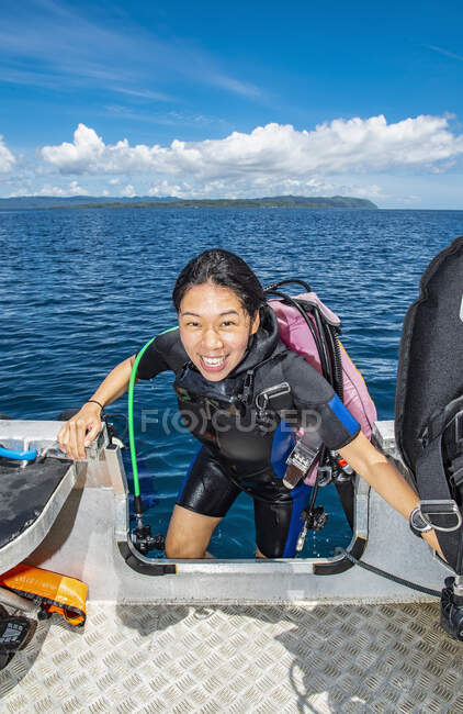 Diver climbing back into dingy after a successful dive in Raja Ampat — Stock Photo