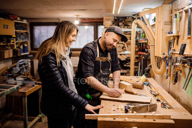 Comunicación del carpintero con la mujer en taller - foto de stock