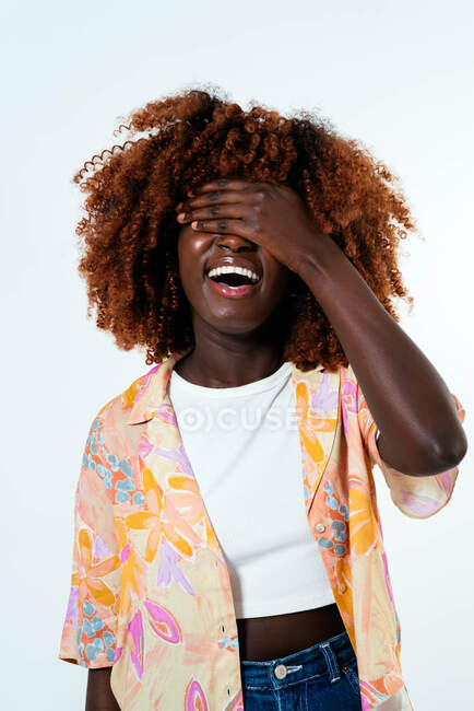 Glücklich Afro-Frau bedeckt ihr Gesicht über weißem Hintergrund — Stockfoto