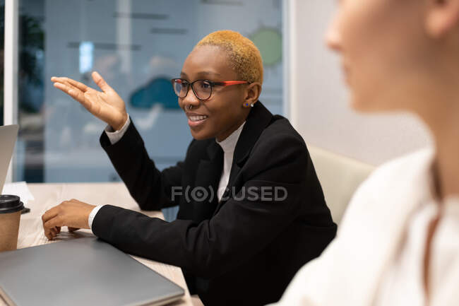 Afroamerikanische Managerin lächelt und spricht während Konferenz im Büro — Stockfoto