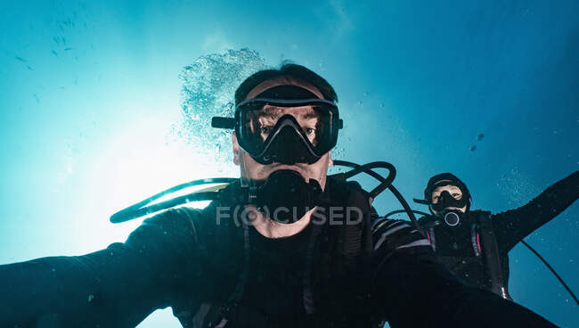Divers taking selfie while descending into the blue at Raja Ampat — Stock Photo