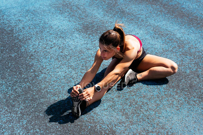 Над молодою жінкою, що тягнеться на біговій доріжці — стокове фото