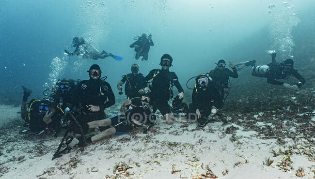 Gruppe von Freunden posiert auf dem Meeresboden in Raja Ampat für die Kamera — Stockfoto