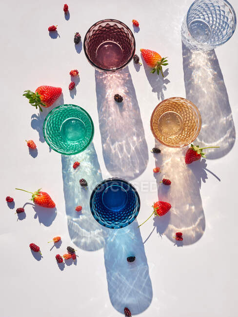 Vista superior de gafas de colores y sombras y bayas, aislado sobre fondo blanco - foto de stock