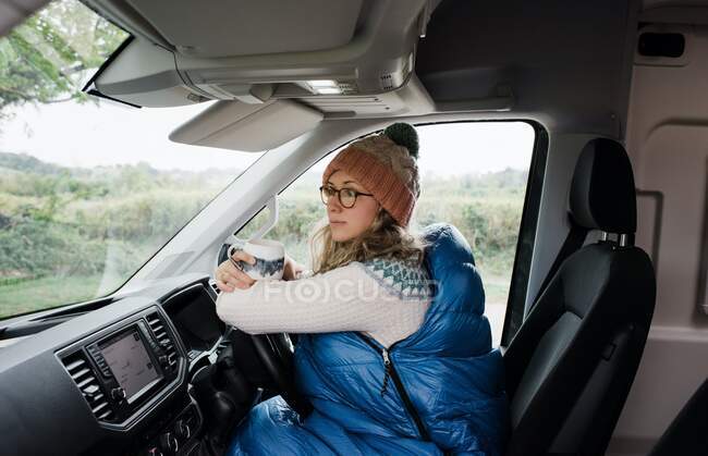 Woman sat in camper van enjoying a cup of tea in the morning — Stock Photo