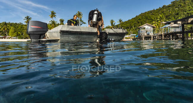 Divers finishing dive and emerging from the ocean at Raja Ampat — Stock Photo