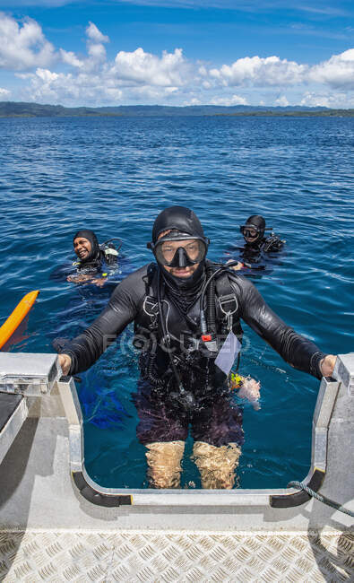 Diver climbing back into dingy after a successful dive in Raja Ampat — Stock Photo