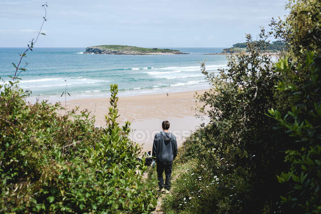 Un garçon marchant dans la nature jusqu'à la plage — Photo de stock