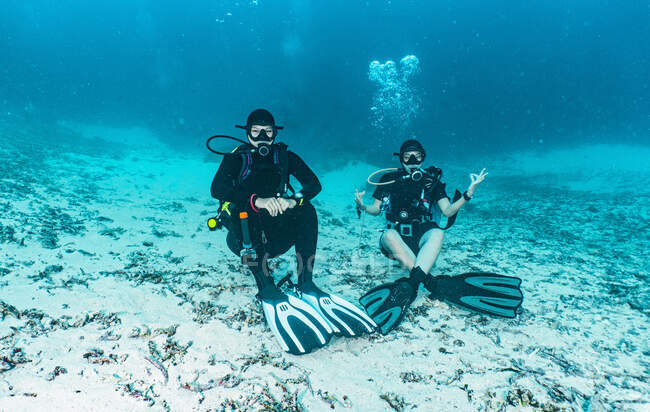 Dois amigos relaxando no fundo do oceano em Raja Ampat — Fotografia de Stock