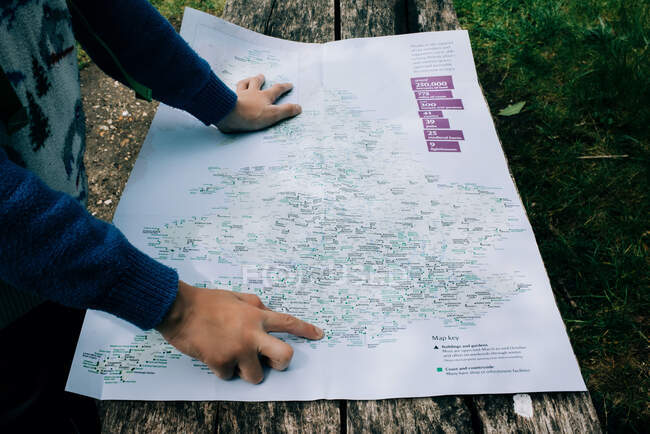 Niño señalando un mapa de Inglaterra mientras explora al aire libre - foto de stock