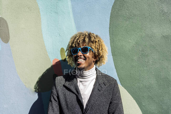 Guapo hombre africano inteligente sonriendo en la calle - foto de stock