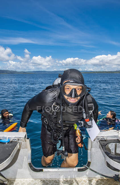 Mergulhador subindo de volta em dingy depois de um mergulho bem sucedido em Raja Ampat — Fotografia de Stock